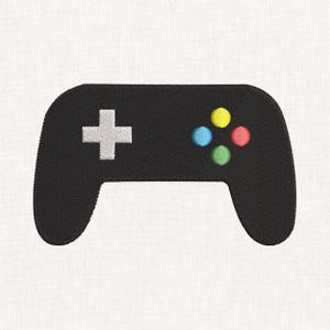 May include: A black embroidered video game controller design featuring a white directional pad on the left side and four circular buttons in yellow, blue, red, and green arranged in a diamond pattern on the right side of the controller.