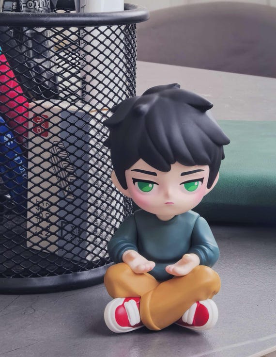 An artist hand-sculpts a tiny chibi caricature of YOU from a photo — it's a mini-me figurine for your desk that no algorithm can auto-generate.