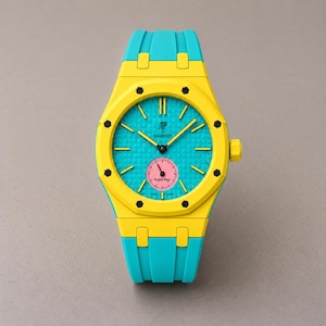 Puede incluir: Un reloj de pulsera de color amarillo brillante y turquesa con un bisel octogonal y ocho tornillos negros. La esfera es turquesa con un patrón de rejilla texturizado, manecillas amarillas y una pequeña subesfera circular rosa con el texto AP X Swatch Royal Pop.