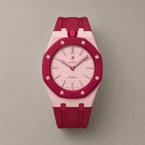 Puede incluir: Un reloj de pulsera con un bisel octogonal rosa oscuro con ocho tornillos plateados, una esfera texturizada rosa claro y una correa de silicona rosa oscuro. La esfera muestra el texto AP, Swatch y Royal Pop, con marcadores y agujas plateados.