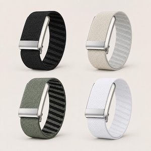 May include: Four elastic watch bands featuring a woven fabric texture and a metallic silver-toned buckle. The bands are available in black, beige, olive green, and white, each showcasing a consistent design with a rectangular metal clasp.