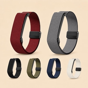 Puede incluir: Una colección de seis correas de reloj en varios colores, incluyendo burdeos, gris, negro, verde oliva, azul marino y blanco. Cada correa presenta una banda de tela texturizada, un cierre magnético rectangular negro y una pieza conectora negra.