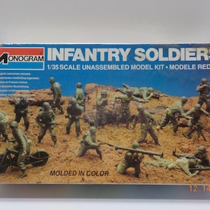 May include: A Monogram model kit box featuring a diorama of green plastic infantry soldiers. The box reads "INFANTRY SOLDIERS" and "1/35 SCALE UNASSEMBLED MODEL KIT." The figures are posed in various action stances, and the box is labeled "MOLDED IN COLOR."