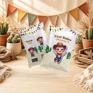 May include: Two white snack bags featuring a cartoon cowboy character, green cactus illustrations, and colourful bunting. One bag displays the text 'First Rodeo Jhonny's' and the other bag displays the text 'Thank You' with a barcode.