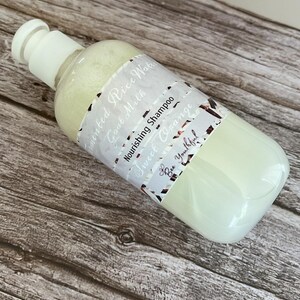 Puede incluir: Una botella de champ&uacute; blanca y transparente con tap&oacute;n blanco. La etiqueta dice "Fermented Rice Water, Goat Milk, Nourishing Shampoo, Sweet Orange, Bee Youthful!". La botella contiene un l&iacute;quido verde claro.