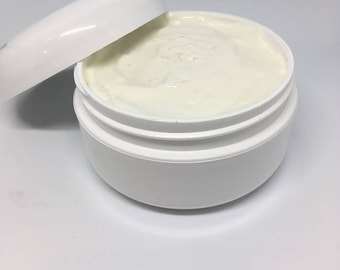 May include: A white plastic jar with a white lid, partially open, filled with a white cream.