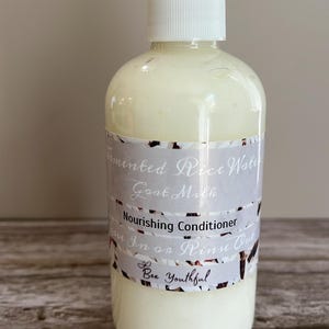Puede incluir: Una botella de pl&aacute;stico blanco con dispensador de bomba, llena de un l&iacute;quido cremoso blanquecino. La etiqueta dice "Fermented Rice Water Goat Milk Nourishing Conditioner". El producto es de "Bee Youthful".