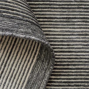 May include: A textile fabric featuring a repeating pattern of thin, dark charcoal gray horizontal stripes alternating with light cream-colored stripes. The material has a visible woven texture with a folded edge showing the reverse side of the fabric.