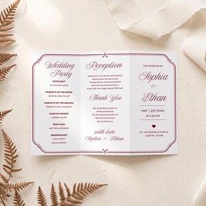 Puede incluir: Un programa de boda tríptico impreso en papel blanco con texto rojo oscuro y un borde decorativo. El texto incluye Wedding Party, Reception, Thank You y los nombres Sophia y Ethan con la fecha 29 de mayo de 20XX a las 4:30 PM en St. Catherine.