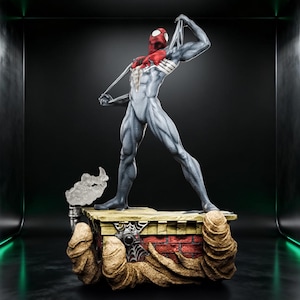 May include: A detailed figurine of a superhero in a grey and red suit, pulling at the fabric near the shoulder. The figure stands on a rectangular base featuring a brick wall design, a small camera, and textured sand-like elements at the corners.