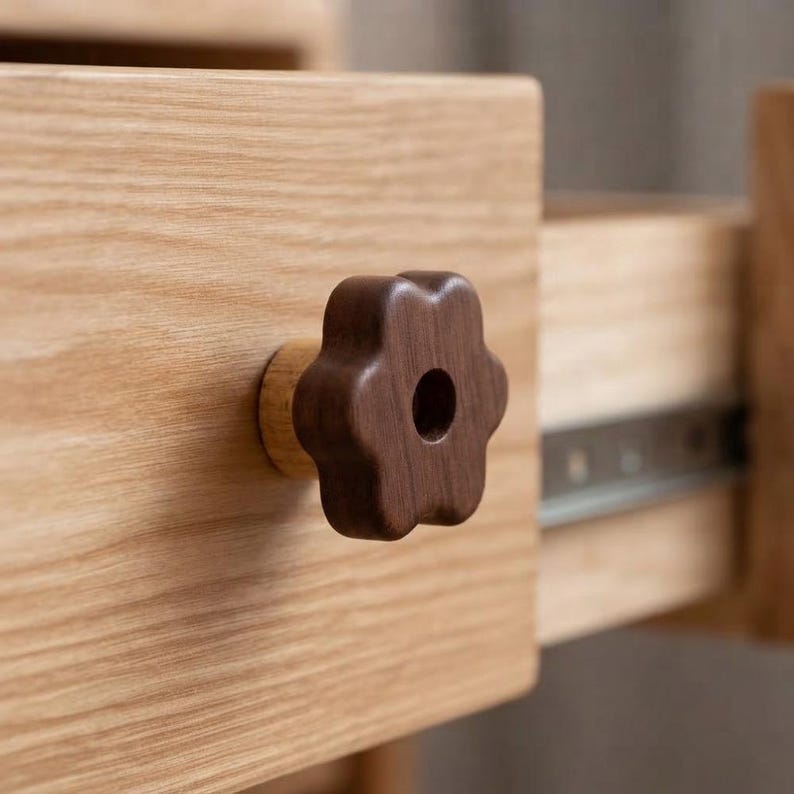 Dark brown wooden flower-shaped drawer knob with central keyhole-inspired detail, rustic vintage cabinet hardware mounted on a natural oak drawer, unique furniture knob for dresser, cabinet, and home decor.