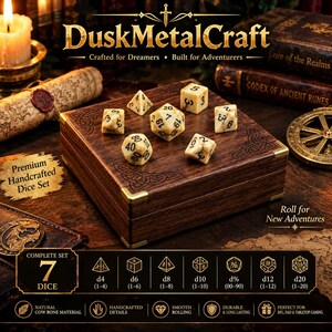 Può includere: Un set di sette dadi poliedrici con finitura marmorizzata color crema e marrone e numerazione nera, disposti su una scatola quadrata in legno con angoli in ottone e incisioni di nodi celtici. I dadi includono le forme d4, d6, d8, d10, d%, d12 e d20.