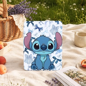 May include: A rectangular tablet case featuring a central illustration of the blue character Stitch from Lilo and Stitch, surrounded by a repeating pattern of various light and dark blue bows against a white background.