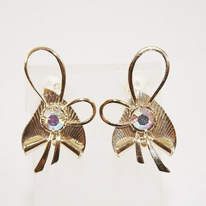 May include: A pair of gold-tone clip-on earrings with a bow design and iridescent rhinestones.