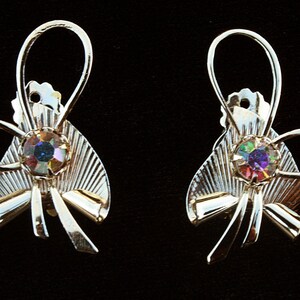 May include: A pair of gold-tone earrings with a bow design and iridescent rhinestones.