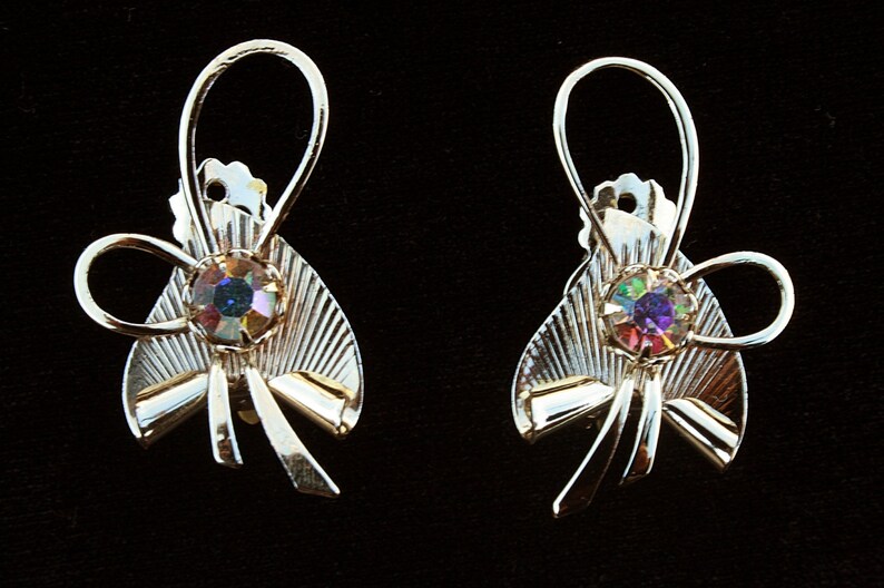 May include: A pair of gold-tone earrings with a bow design and iridescent rhinestones.