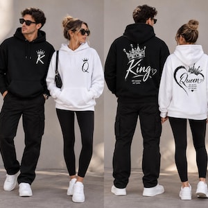 Può includere: Una felpa nera con cappuccio, corona bianca e lettera K sul petto, con una grande corona, la scritta King e il testo My Queen, My Life sul retro. Una felpa bianca con cappuccio, corona e lettera Q sul petto e un cuore con corona sul retro.