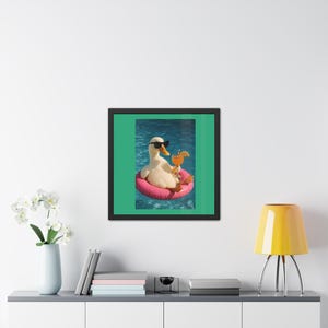 May include: A framed wall art print featuring a white duck wearing black sunglasses, floating in blue water on a pink circular pool float, while holding an orange cocktail with a slice of fruit in its wing, set against a solid green background.