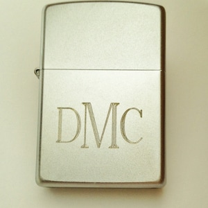 May include: Silver lighter with the initials "DMC" engraved on the front.