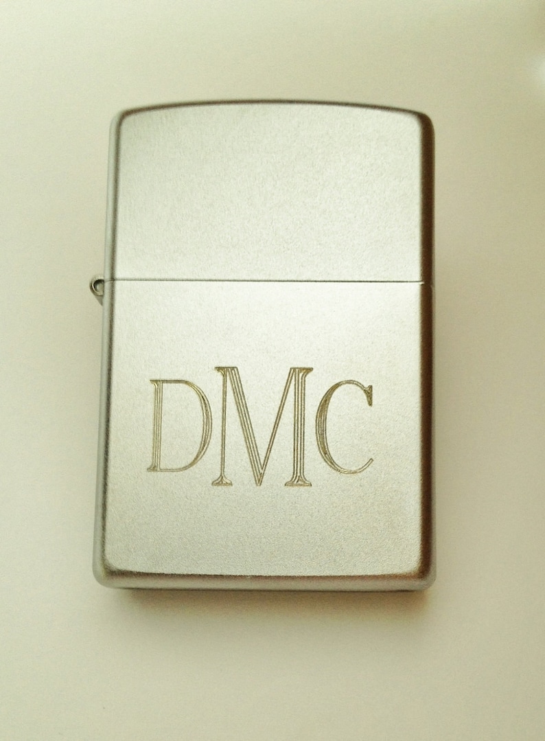 May include: Silver lighter with the initials "DMC" engraved on the front.