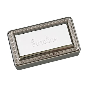May include: Silver rectangular jewelry box with a beaded border and the name "Caroline" engraved on the lid.