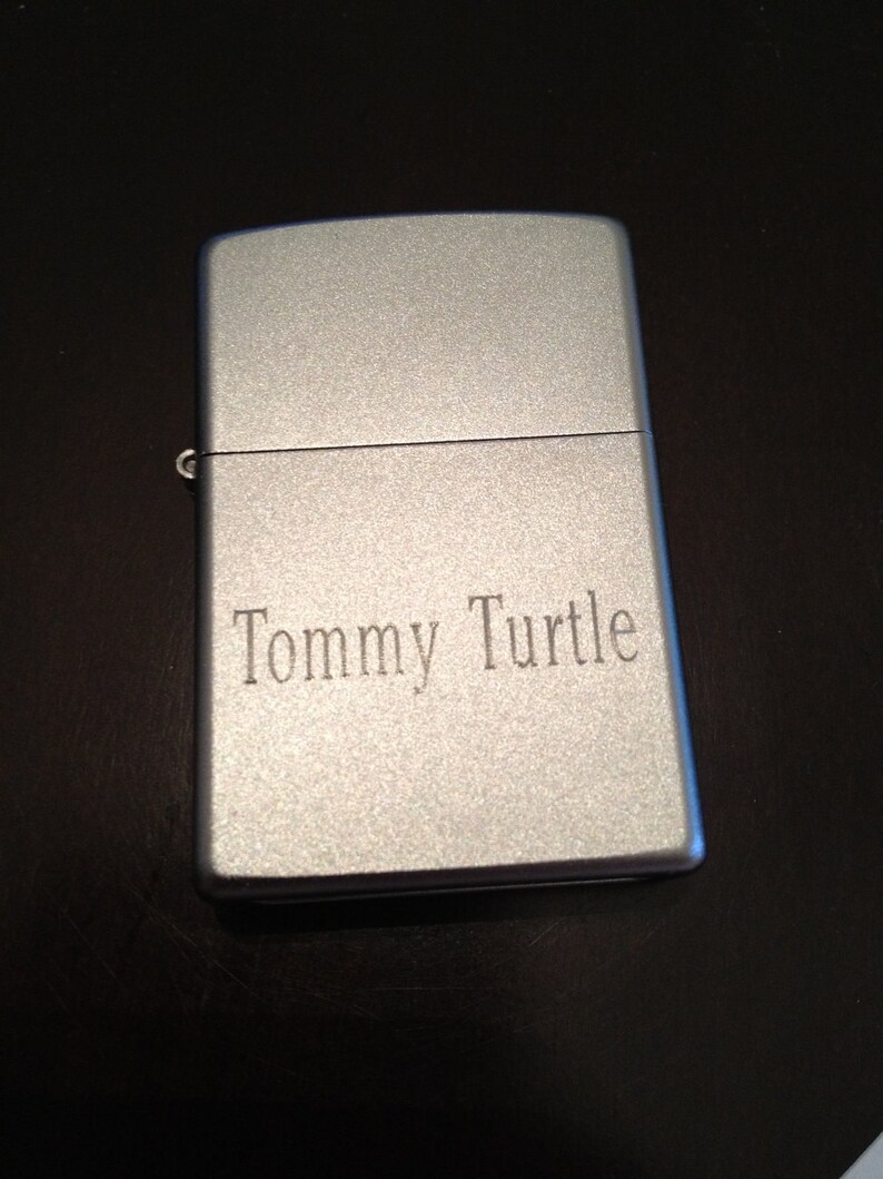 May include: A silver lighter with the name "Tommy Turtle" engraved on the front.