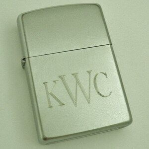 May include: A silver lighter with the initials "KWC" engraved on the front.