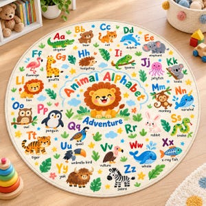 May include: A round area rug featuring a colorful alphabet design with illustrations of animals for each letter from A to Z. The center displays a cartoon lion and the text Animal Alphabet Adventure. The background is cream with green leaves and yellow stars.