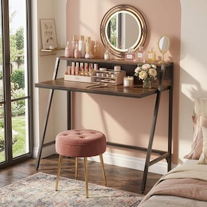 May include: A dark wood vanity desk with a black metal frame, featuring a round LED mirror, a shelf with various cosmetic bottles, and a makeup organizer. A round, tufted, dusty pink velvet stool with gold-toned legs sits in front of the desk.