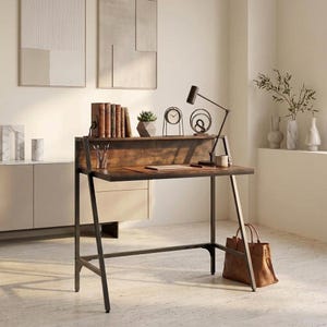 May include: A dark brown wooden desk with a black metal frame, featuring a raised shelf, a flat work surface, and a support bar. The desk holds a row of books, a small potted succulent, a round clock, a decorative sculpture, and a desk lamp.