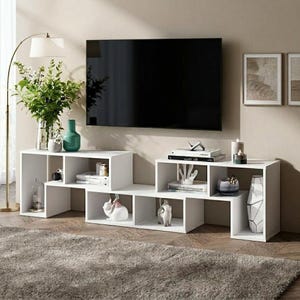 May include: A white modular media console featuring a stepped, multi-level design with open rectangular shelving compartments. The unit is constructed from smooth white panels and provides various storage spaces for books, decorative objects, and electronics.