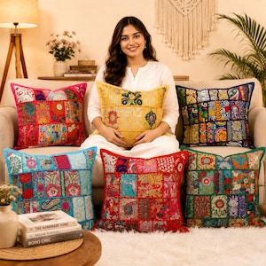 Puede incluir: Cinco cojines cuadrados con complejos diseños de patchwork que presentan vibrantes patrones florales y geométricos en tonos rosa, amarillo, azul, rojo y verde. Cada cojín está construido con múltiples paneles de tela con bordados.