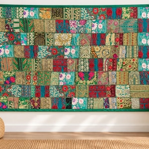Può includere: Un arazzo rettangolare caratterizzato da un design patchwork composto da numerosi piccoli quadrati di tessuto. Il tessuto presenta una vivace gamma di colori tra cui verde smeraldo, rosso intenso, oro e blu, con intricati motivi floreali e geometrici.