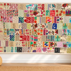 May include: A rectangular wall hanging featuring a patchwork design composed of numerous small fabric squares. The textile displays a vibrant array of colors including red, blue, green, orange, and pink, with various floral, paisley, and geometric patterns.