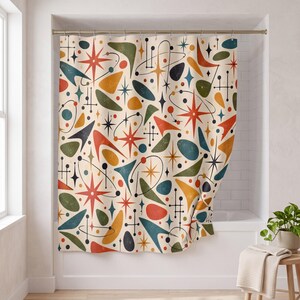 May include: A shower curtain featuring a cream-colored background with a repeating pattern of orange, teal, and olive green geometric shapes, including boomerangs, starbursts, and orbital lines with small dots, creating a multi-colored design.