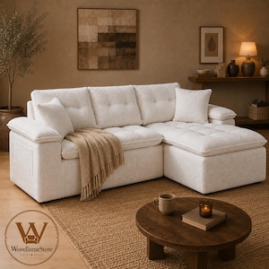 May include: A cream-colored sectional sofa with a textured fabric finish, featuring three back cushions with button tufting, two side cushions, and a chaise lounge section. A tan fringed throw blanket is draped over the seat cushions.