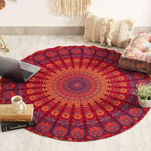 Peut inclure: Une grande tapisserie circulaire présentant un motif mandala vibrant dans des tons de rouge profond, d'orange et de violet. Le design complexe rayonne à partir d'un point central avec des motifs répétitifs en goutte et floraux.