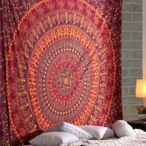 Könnte beinhalten: Ein großer rechteckiger Wandteppich mit einem lebendigen, kreisförmigen Mandala-Design in tiefen Rot-, Orange- und Gelbtönen. Das komplexe Muster enthält sich wiederholende Blumenmotive und stilisierte Elefantenfiguren in konzentrischen Ringen.