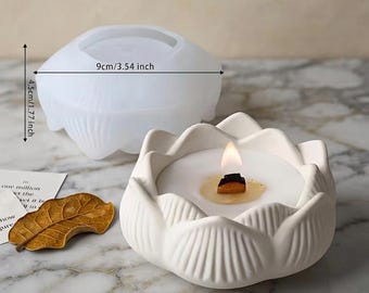 May include: A white lotus-shaped candle holder with a lit candle and a translucent silicone mold. The mold features printed dimensions of 3.54 inches in width and 1.77 inches in height. A dried brown leaf rests nearby on the surface.