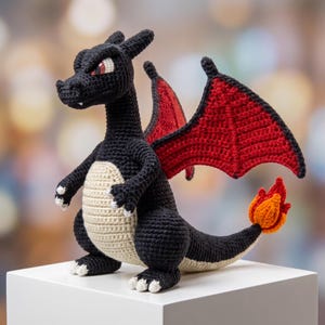 May include: A black crocheted dragon plush toy featuring a cream-colored belly, red inner wings with black borders, and a flame-tipped tail. The creature has sharp, angular features, red eyes, and white claws on its hands and feet, crafted with detailed yarn stitching throughout the entire body.