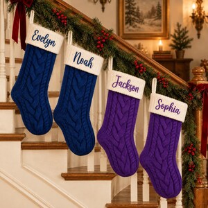 May include: Four cable-knit Christmas stockings hanging in a row. The first two are blue with white cuffs embroidered with the names Evelyn and Noah. The last two are purple with white cuffs embroidered with the names Jackson and Sophia.