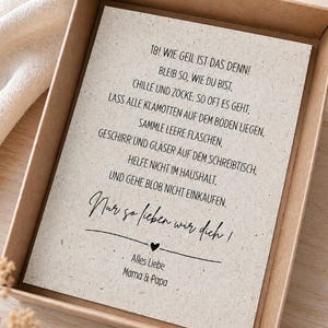 May include: A rectangular greeting card with a speckled, light beige paper texture inside a brown cardboard box. The card features black printed German text that reads: 18! WIE GEIL IST DAS DENN! BLEIB SO, WIE DU BIST, CHILLE UND ZOCKE, SO OFT ES GEHT, LASS ALLE KLAMOTTEN AUF DEM BODEN LIEGEN, SAMMLE LEERE FLASCHEN, GESCHIRR UND GL&Auml;SER AUF DEM SCHREIBTISCH, HELFE NICHT IM HAUSHALT, UND GEHE BLOB NICHT EINKAUFEN. Nur so lieben wir dich! ALLES LIEBE MAMA & PAPA.