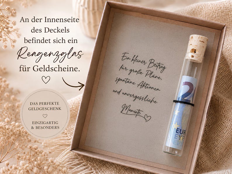 May include: A rectangular cardboard gift box containing a glass test tube with a cork stopper. Inside the tube is a rolled-up Euro banknote. The box features German text printed on the inner lid and a central card with German script text.