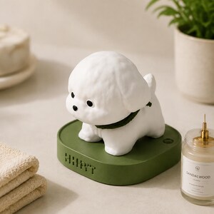 May include: A white dog-shaped night light with a dark green collar, standing on a rounded olive green base. The base features the embossed text "HHIPT" on the front side and a small circular power button on the top surface near the dog figure.