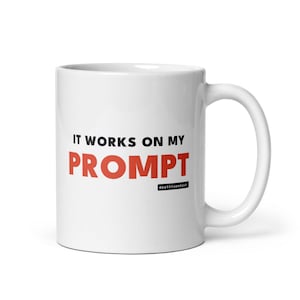 Może przedstawiać: Biały ceramiczny kubek z czarnym napisem IT WORKS ON MY oraz czerwonym napisem PROMPT, z małym czarnym prostokątnym logo zawierającym biały napis deathtoendash umieszczonym pod słowem PROMPT na boku kubka.