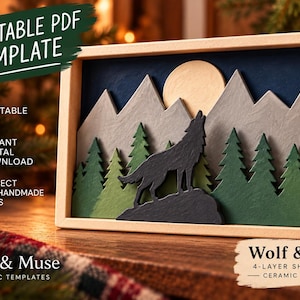 Può includere: Una scatola d'ombra a quattro strati con un lupo che ulula alla luna, davanti a montagne grigie e pini verdi in una cornice di legno chiaro. Il testo include PRINTABLE PDF TEMPLATE, A4 PRINTABLE PDF, INSTANT DIGITAL DOWNLOAD e WOLF & MOON.