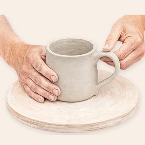 Könnte beinhalten: Ein hellgrauer, unfertiger Tonbecher mit einem abgerundeten Henkel, der auf einer runden Töpferscheibe aus Holz steht. Der Becher hat eine glatte, matte Oberflächenstruktur und eine weite Öffnung, die die rohe Form des Gefäßes zeigt.