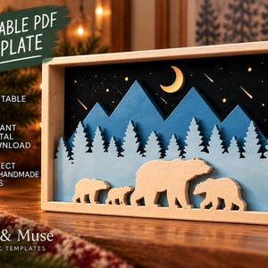 Può includere: Una cornice rettangolare in legno contenente una scena in carta a strati. La scena presenta un cielo notturno blu scuro con una luna crescente gialla e stelle, sagome di montagne blu, pini azzurri e quattro orsi color beige.