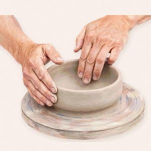 May include: A light gray, unfinished clay bowl centered on a circular pottery wheel. The bowl has a smooth, rounded rim and a thick, solid base. The pottery wheel surface features faint, swirling streaks of blue, pink, and brown paint.