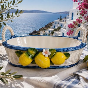 May include: An oval ceramic basket with a cream-colored woven texture, featuring two twisted rope-style handles and a blue rim. The front is decorated with three bright yellow lemons, green leaves, and a small white flower with a pink center.